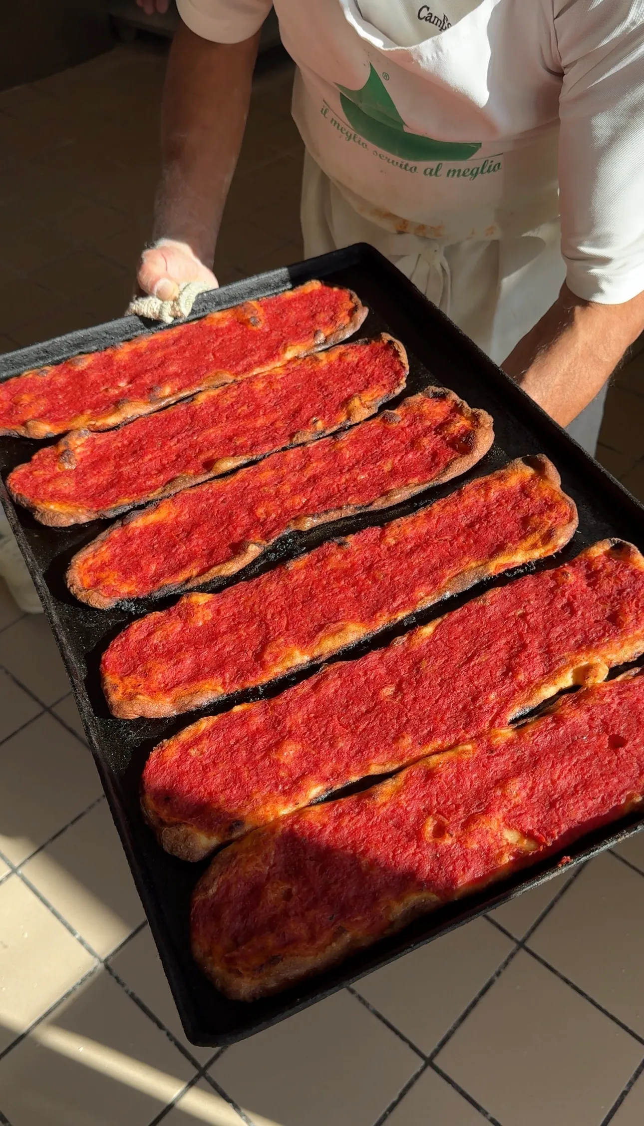 Una teglia di pizza rossa appena sfornata al Forno Campo de' Fiori